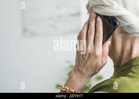 Die Hand einer älteren Frau mit dem Mobiltelefon. Hochwertige Fotos Stockfoto