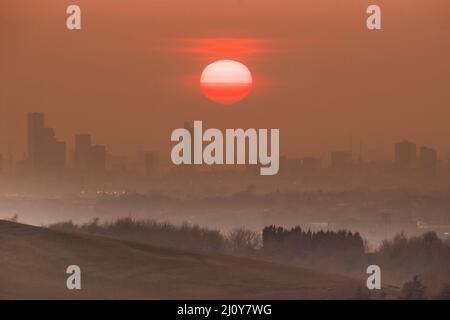 Die Sonne untergeht hinter der Stadt Manchester am Vernal Equinox, dem astronomischen ersten Frühlingstag Stockfoto