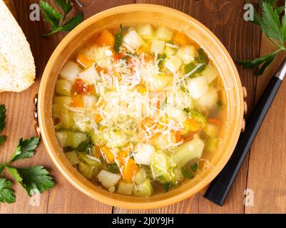 Schüssel Minestrone Suppe mit Toast auf rustikalem Holzhintergrund, Draufsicht. Stockfoto