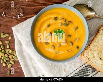 Vegetarische Ernährung pupmkin Creme Suppe pürieren, Auf dunkelbraunem Holz- Tabelle, Ansicht von oben, in der Nähe auf. Stockfoto
