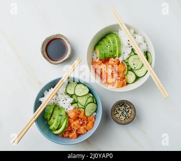 Lachsschüssel mit frischem Fisch, Reis, Gurke, Avocado Stockfoto