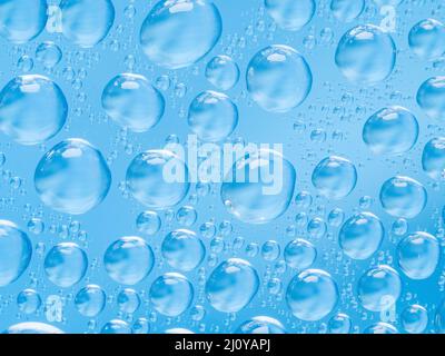 Abstrakt Blau Hintergrund mit großen und kleinen sphärischen konvexen Tropfen Wasser auf Glas. Blasen im Fenster". Makro Nahaufnahme. Stockfoto