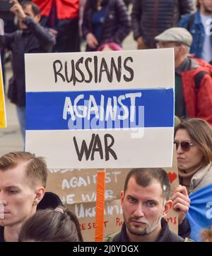 London, Großbritannien. 20.. März 2022. Ein Protestler hält ein Schild mit einer symbolischen russischen Flagge mit blauen und weißen Farben, und das rote entfernt, und die Worte "Russen gegen den Krieg". Auf dem Trafalgar-Platz versammeln sich weiterhin große Menschenmengen zur Unterstützung der Ukraine, während Russland seinen Angriff verstärkt. Stockfoto