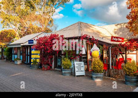 Adelaide Hills, South Australia - 24. April 2021: Kleine Geschäfte, die während der Herbstsaison bei Sonnenuntergang entlang der Straße in Hahndorf besichtigt werden können Stockfoto