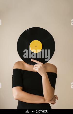 Junge Frau hält Schallplatten in ihrem Gesicht. Hochwertige Fotos Stockfoto