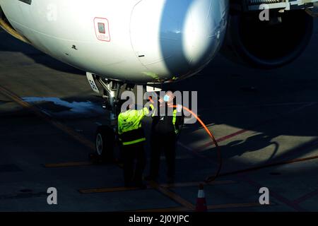 QINGDAO, CHINA - 21. FEBRUAR 2021 - Bodenpersonal füllt Kraftstoff für ein Passagierflugzeug von China Eastern Airlines am Flughafen Liuting in Qingdao, Shandong P Stockfoto