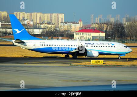 QINGDAO, CHINA - 21. FEBRUAR 2021 - Ein Passagierflugzeug von Xiamen Airlines taxiert auf der Start- und Landebahn des Flughafens Liuting in Qingdao, dem ostchinesischen Flughafen Shandong Stockfoto