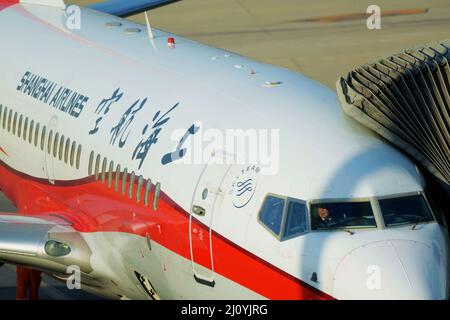 QINGDAO, CHINA - 21. FEBRUAR 2021 - Ein Passagierflugzeug von Shanghai Airlines lädt Passagiere am Liuting Airport in Qingdao, dem ostchinesischen Shandong-Profi, herunter Stockfoto