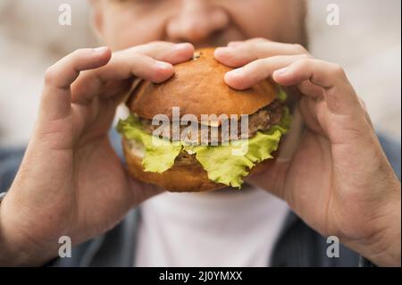 Nahaufnahme Mann essen Burger. Hochwertige Fotos Stockfoto