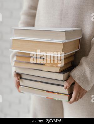 Nahaufnahme der Hände, die den Stapel der Bücher halten. Hochwertige Fotos Stockfoto