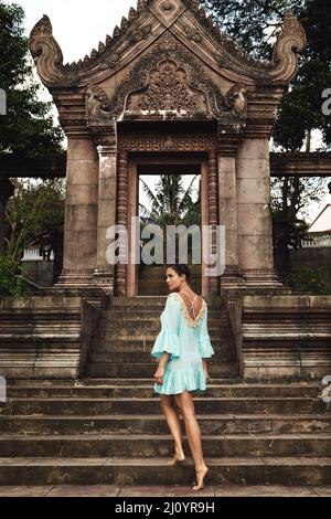 Junge Frau, die neben uralten Khmer-Ruinen posiert Stockfoto