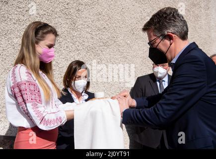 München, Deutschland. 21. März 2022. Der Wissenschaftsminister von Bayern, Markus Blume (CSU), besucht die Ukrainische Freie Universität München (UFU) und wird von einem Studenten in ukrainischer Tracht mit Brot und Salz begrüßt. Die UFU ist die einzige ukrainische Universität im Exil außerhalb der Ukraine. Quelle: Sven Hoppe/dpa/Alamy Live News Stockfoto