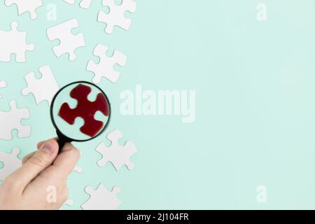 Puzzleteile mit Lupe Stockfoto
