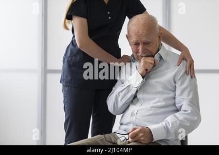 Krankenschwester tröstet alten weinenden Mann Stockfoto