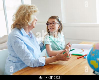 Hausaufgaben Unterricht Bildung Großmutter Kinder Enkelin Familie Kindheit Kind Lehrer Klassenzimmer Senior Farbe Färbung Malerei Buch Notizbuch Stockfoto