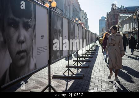 (220321) -- MOSKAU, 21. März 2022 (Xinhua) -- am 20. März 2022 besuchen die Menschen die Fotoausstellung "Schau in die Augen des Donbass" in der Arbat-Straße in Moskau, Russland. (Xinhua/Bai Xueqi) Stockfoto