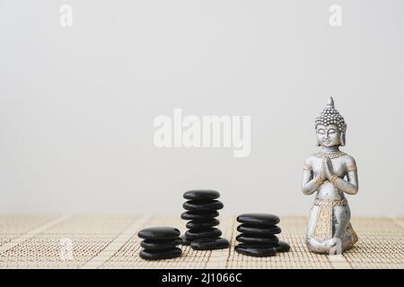 Buddha-Figur mit schwarzen Steinen Stockfoto