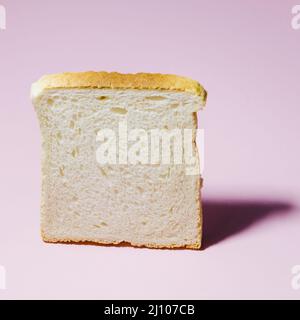 Brot mit farbigem Hintergrund in Scheiben schneiden Stockfoto