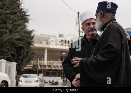 Jerusalem, Israel. 21. März 2022. Ein Drusenführer (L) und ein äthiopischer Kirchenpriester (R) begrüßen sich gegenseitig, während sich christliche, jüdische, muslimische und drusische Religionsführer versammeln, um auf dem Moskwa-Platz in Jerusalem öffentlich zum Frieden in der Ukraine zu rufen. Diese Versammlung folgt auf die Übergabe eines interreligiösen Briefes an den russisch-orthodoxen Patriarchen Kirill, in dem er dazu aufgerufen wurde, mit Präsident Putin zu sprechen, um Frieden zu suchen. Der Brief wurde von 150 Jerusalems und globalen religiösen Führern und Geistlichen unterzeichnet. Kredit: Nir Alon/Alamy Live Nachrichten Stockfoto