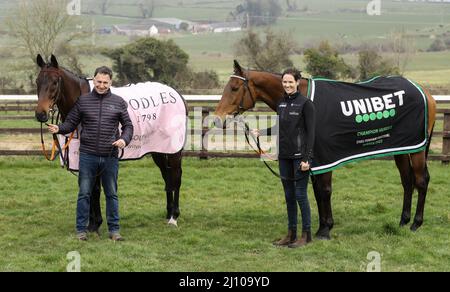 Rachael Blackmore mit Champion Hurdle Sieger Honeysuckle (rechts) und Henry de Bromhead mit Gold Cup Siegerpferd, Einem Plus Tard (links) während der Heimkehr im Henry de Bromhead Training Yard, Knockeen, Co. Waterford. Bilddatum: Montag, 21. März 2022. Stockfoto