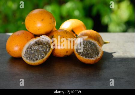 Das Foto zeigt eine exotische Frucht aus den Tropen. Die tropische Frucht wird Granadilla oder süße Passionsfrucht genannt. Granadilla ist orange in der Farbe wi Stockfoto