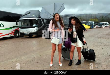 Zwei irische Mädchen, die nach zwei Renntagen nach Hause gehen und nach ihrer Fahrt zum Bahnhof suchen. Tag 2, Rennen beim Cheltenham Gold Cup Festival Stockfoto