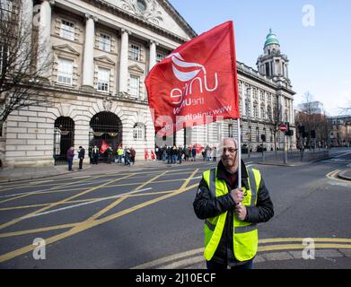 John Moore, Mitglied der Sicherheitseinheit des Stadtrats von Belfast und Shop Stewards von Unite Union, steht mit Kollegen und Kollegen auf der Streikschnur am hinteren Eingang des Belfast City Hall. Bilddatum: Montag, 21. März 2022. Stockfoto