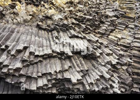 Felssäulen, die aus basaltischer Lava in Küstenklippen am Strand von Reynisfjara in der Nähe von Vik, Südküste Islands, entstanden sind. Stockfoto