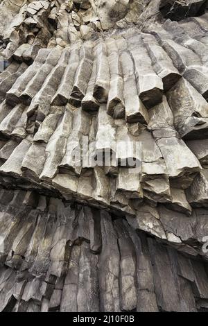 Felssäulen, die aus basaltischer Lava in Küstenklippen am Strand von Reynisfjara in der Nähe von Vik, Südküste Islands, entstanden sind. Stockfoto