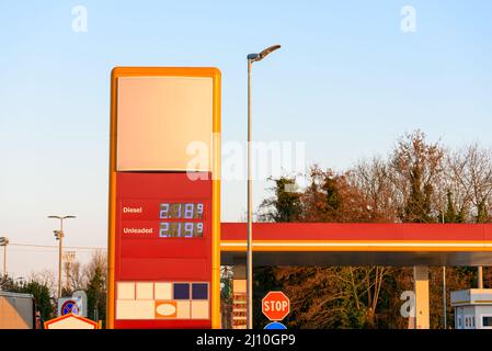 Tankstellenschild an einer Autobahn unter klarem Himmel bei Sonnenuntergang im Winter. Steigende Benzinpreise. Stockfoto