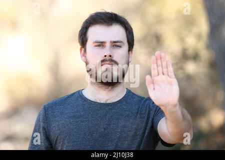Vorderansicht Porträt eines wütenden Mannes gestikuliert Stop mit der Hand im Freien Stockfoto