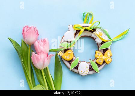 Frohe Ostern mit rosa Tulpen und Keksen. Osterhintergrund Stockfoto