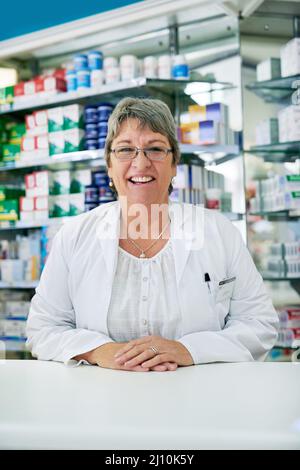 Sprechen Sie mit mir für alle Ihre gesundheitlichen Fragen. Porträt einer glücklichen reifen Frau, die in einer Apotheke arbeitet. Stockfoto