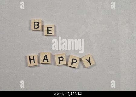 „Be happy“-Satz auf weißem Keramikhintergrund Stockfoto
