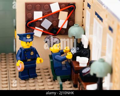 Tambow, Russische Föderation - 02. August 2021 zwei Lego-Polizisten in der Polizeistation, einer davon, einen Donut zu essen, und ein anderer, tippt auf einen Typ Stockfoto