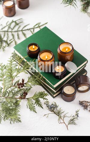 Ein Set verschiedener Duftkerzen in braunen Glasgefäßen. Handgemachte Duftkerze. Sojalkerzen brennen in einem Glas. Aromatherapie und entspannen Sie sich im Spa und zu Hause. Stillleben. Feuer in braunem Glas Stockfoto