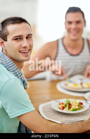 Paare, die zusammen essen, bleiben zusammen. Portrait eines schwulen Paares, das zusammen zu Mittag gegessen hat. Stockfoto