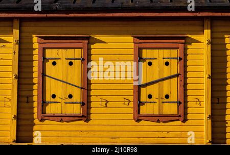 Vorderansicht der gelben Holzfenster bei Tageslicht Stockfoto