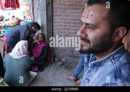 21. März 2022, Srinagar, Jammu und Kaschmir, Indien: Eine Frau erhält eine Bluttherapie auf einer flachen Seite eines Sees in Srinagar, im indisch verwalteten Kaschmir. Am ersten Frühlingstag des persischen Kalenders Nowruz und Anfang des Jahres verwenden traditionelle Gesundheitsexperten in Kaschmir Blutegel zur Behandlung von Patienten, die an Hautkrankheiten, Arthritis, chronischen Kopfschmerzen und Sinusitis leiden. (Bild: © Adil Abbas/ZUMA Press Wire) Stockfoto