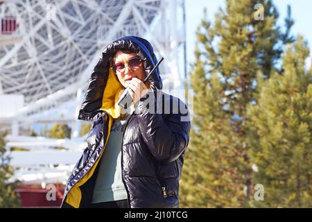 Eine Frau, die auf einem Walkie-Talkie spricht Stockfoto