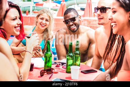 Multikulturelle trendige Freunde haben Spaß beim Biertrinken im Sommerurlaub - Lifestyle-Reisekonzept mit jungen Leuten, die Brauflaschen zu Luxus toasten Stockfoto