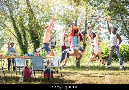 Multirassische Freunde springen auf Grill pic nic Gartenparty - Freundschaft multikulturelles Konzept mit jungen glücklichen Menschen Spaß beim Tanzen auf spri Stockfoto
