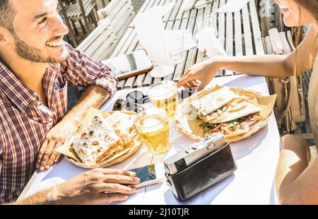 Verliebtes Paar, das auf einem Ausflug im Street Food Restaurant Spaß hat - Junge glückliche Touristen, die einen glücklichen Moment in der Bierbar genießen - Beziehungsgekonp Stockfoto