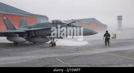 Thule, Grönland. 16. März 2022. Ein Royal Canadian Air Force CF-18 Kampfjet von 425 Tactical Fighter Squadron, bereitet sich auf das Taxi vor, um während der Operation Noble Defender am 16. März 2022 in Thule AFB, Grönland, im Schneefall abzufahren. Die NORAD-Übung ist Teil der jüngsten militärischen Schritte, um die russische Beteiligung in der Ukraine zu verhindern. KREDIT: CANR NORAD/US Air Force/Alamy Live News Stockfoto