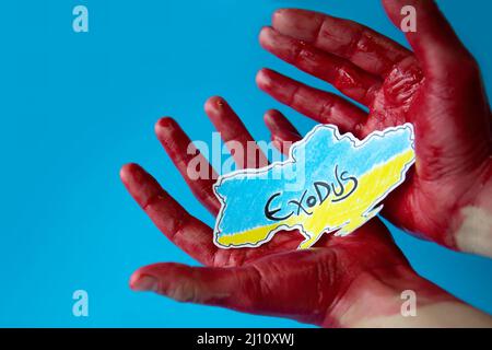 Blutige Hände auf blauem Hintergrund mit einem Papierausschnitt der in den Farben ihrer Flagge gemalten Karte der ukraine. Massenflucht von Zivilbürgern. Stockfoto