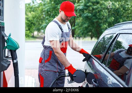 Tankstellenbegleiter Tankfüllung des Kundenwagens Stockfoto