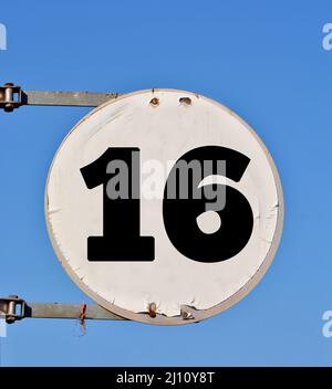 Rundes Straßenbanner mit der Nummer 16 im Hintergrund des Himmels. Stockfoto