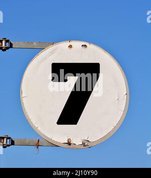 Ein rundes Straßenbanner mit der Nummer 7 im Hintergrund des Himmels. Stockfoto