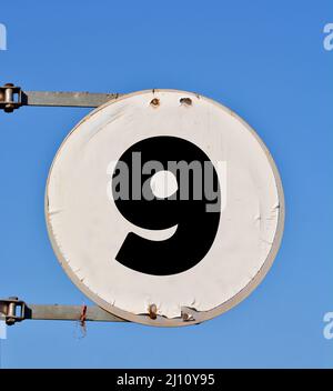 Rundes Straßenbanner mit der Nummer 9 im Hintergrund des Himmels. Stockfoto