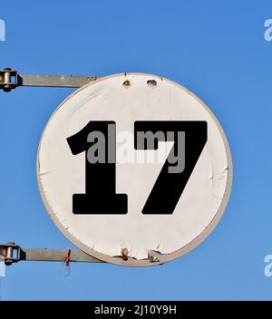 Rundes Straßenbanner mit der Nummer 17 im Hintergrund des Himmels. Stockfoto